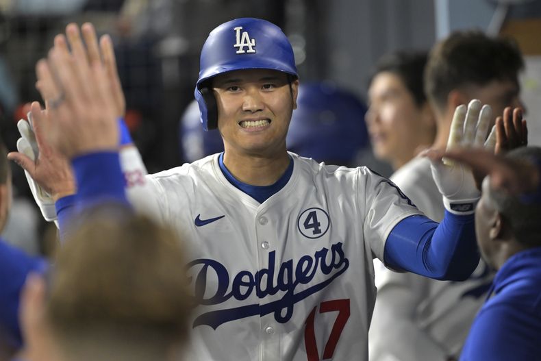 Shohei Ohtani, de los Dodgers de Los Ángeles, es felicitado en el dugout después de batear un cuadrangular solitario en la séptima entrada del juego de béisbol de Grandes Ligas contra los Mets de Nueva York, el lunes 2 de junio de 2025, en Los Ángeles. (AP Foto/Jayne Kamin-Oncea)