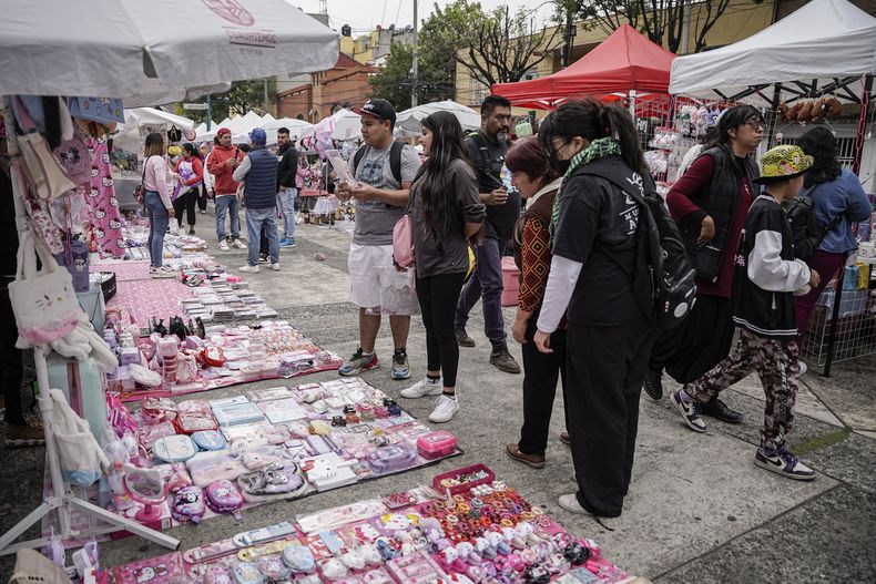Fans del personaje japonés Hello Kitty miran productos en un mercado callejero con temática de Hello Kitty en la Ciudad de México, el sábado 5 de octubre de 2024. (Foto AP/Aurea Del Rosario)
