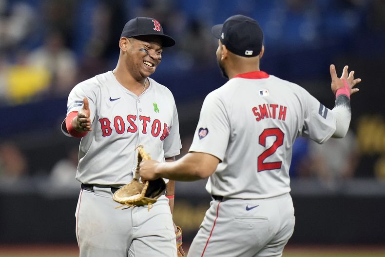 El tercera base de los Medias Rojas de Boston, Rafael Devers, izquierda, y el primera base Dominic Smith celebran después de vencer a los Rays de Tampa Bay durante el juego de béisbol del lunes 20 de mayo de 2024, en San Petersburgo, Florida. (AP Foto/Chris OMeara)