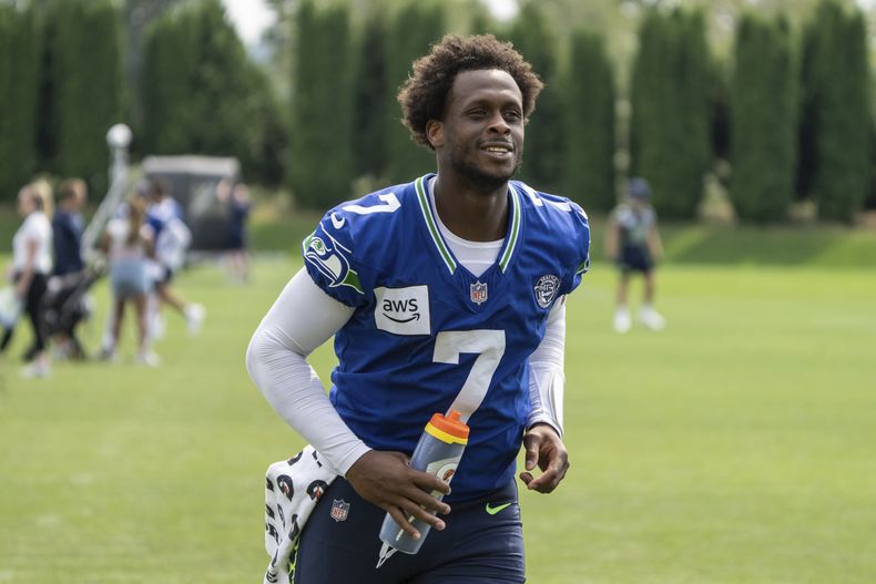 El mariscal de campo de los Seattle Seahawks, Geno Smith, sale corriendo del campo después de una práctica del campamento de entrenamiento de la NFL, el sábado 27 de julio de 2024, en Renton, Washington (AP Foto/Stephen Brashear)