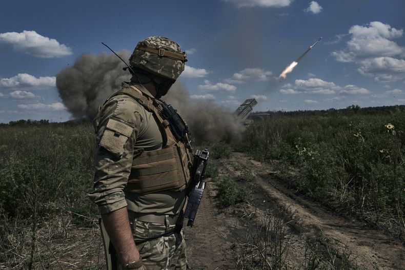Un soldado ucraniano observa un sistema de lanzacohetes múltiple que dispara proyectiles cerca de Bájmut, en la región de Donetsk, Ucrania, el domingo 13 de agosto de 2023. (AP Foto/Libkos)