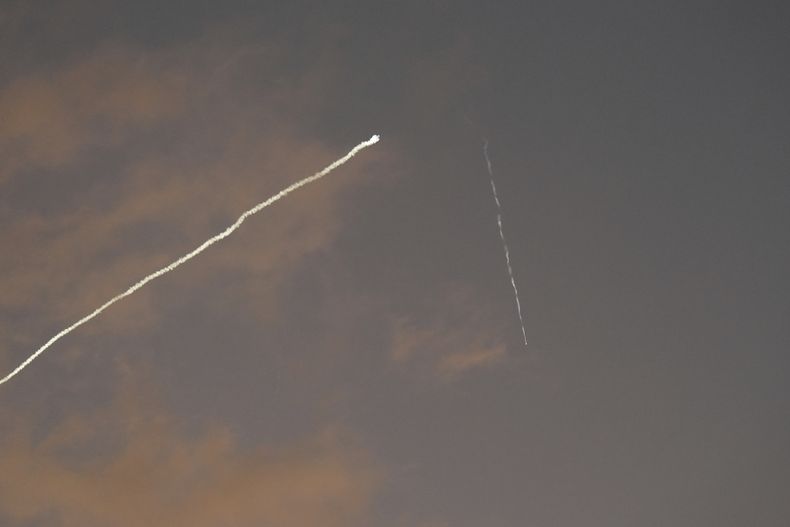 Una estela de humo del sistema de defensa aérea israelí Cúpula de Hierro atraviesa el cielo para interceptar misiles lanzados desde Irán, vista desde Haifa, Israel, la madrugada del martes 24 de junio de 2025. (AP Foto/Baz Ratner)