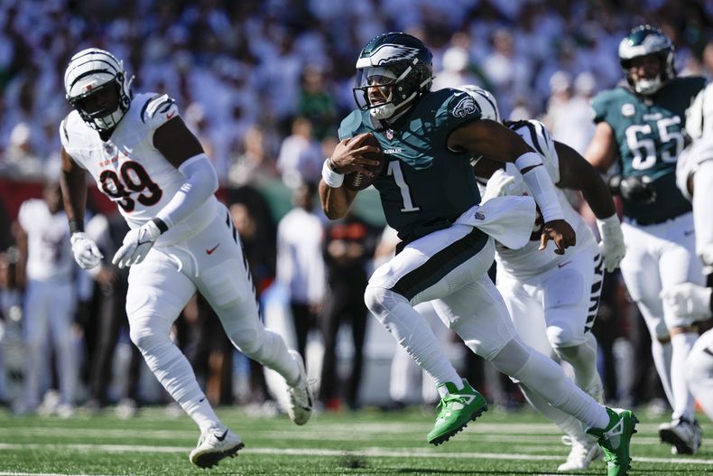 Jalen Hurts (1), quarterback de los Eagles de Filadelfia, corre con el balón, mientras Myles Murphy (99), de los Bengals de Cincinnati, intenta alcanzarlo durante la primera mitad del juego de la NFL, el domingo 27 de octubre de 2024, en Cincinnati. (AP Foto/Carolyn Kaster)