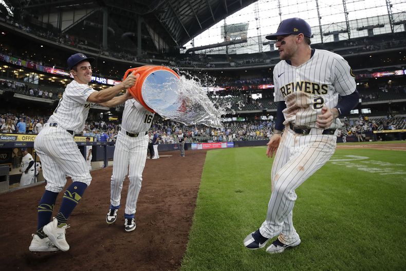 Brice Turang (2), de los Cerveceros de Milwaukee, evita ser salpicado por Blake Perkins (16) y Sal Frelick después de vencer a los Marlins de Miami, el domingo 28 de julio de 2024, en Milwaukee. (AP Foto/Aaron Gash)