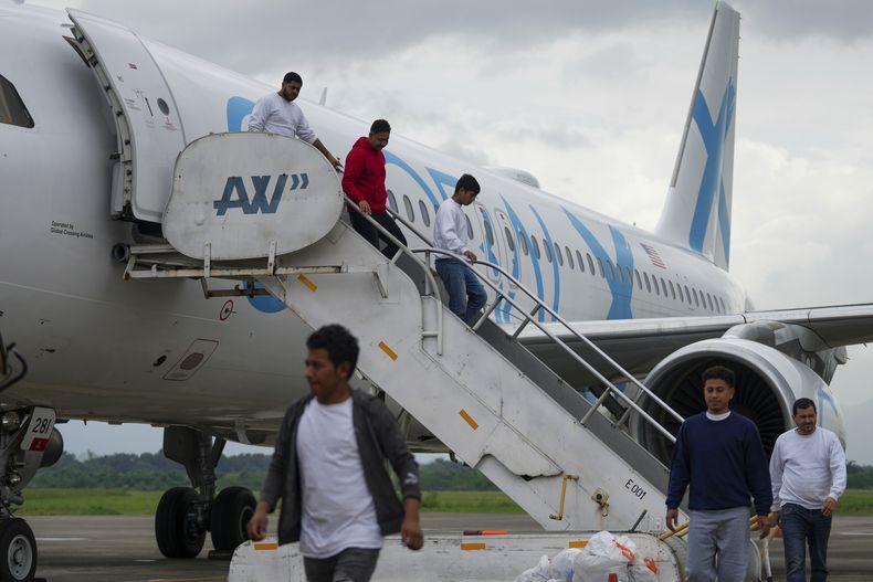 ARCHIVO - Migrantes hondureños que fueron deportados de Estados Unidos descienden de un avión en el Aeropuerto Ramón Villeda Morales, en San Pedro Sula, Honduras, el 4 de diciembre de 2024. (AP Foto/Moises Castillo, Archivo)