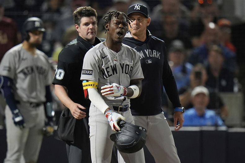 Jazz Chisholm Jr., centro, de los Yankees de Nueva York, reacciona después de haber sido puesto out con strike cantado por parte del umpire principal John Bacon, izquierda, durante la séptima entrada del juego de béisbol de Grandes Ligas ante los Rays de Tampa Bay el jueves 17 de abril de 2025, en Tampa, Florida. (AP Foto/Chris OMeara)