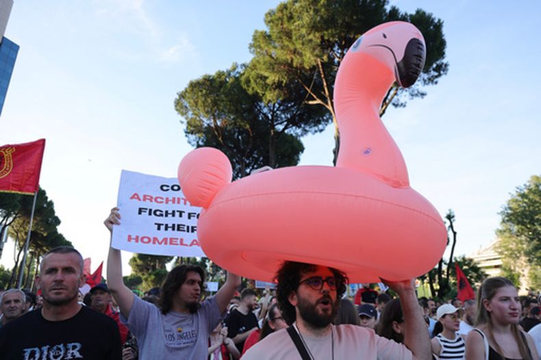 Una persona lleva un flamingo inflable durante una manifestación en Tirana, el sábado 13 de junio de 2026, contra la construcción de un enorme proyecto costero vinculado a Jared Kushner e Ivanka Trump en la zona de la laguna de Narta, Albania. (Foto AP/Hameraldi Agolli)