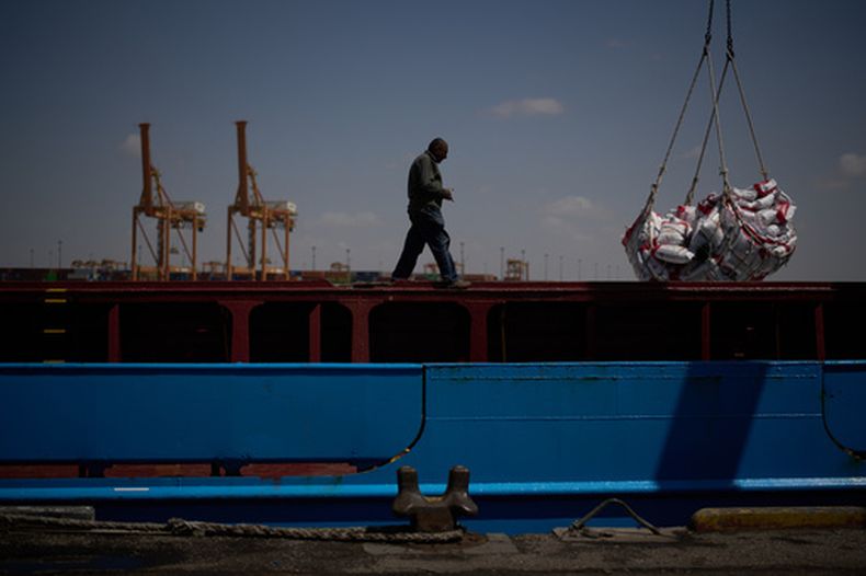 Un trabajador camina por el muelle de un barco mientras trabaja para descargar un cargamento de arroz en el puerto de Umm Qasr, en Irak, el viernes 27 de marzo de 2026. (AP Foto/Leo Correa)