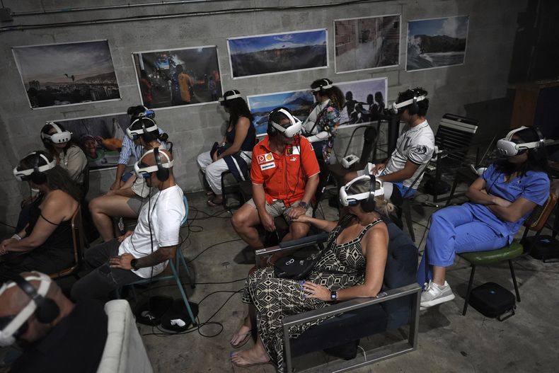 Gente con accesorios de realidad virtual para experimentar el documental Teleport to Venezuela, de 35 minutos, mientras comienza la promoción nacional y europea del documental en la comunidad venezolana más grande de EEUU en Doral, Florida, el sábado 5 de abril de 2025. (AP Foto/Rebecca Blackwell)