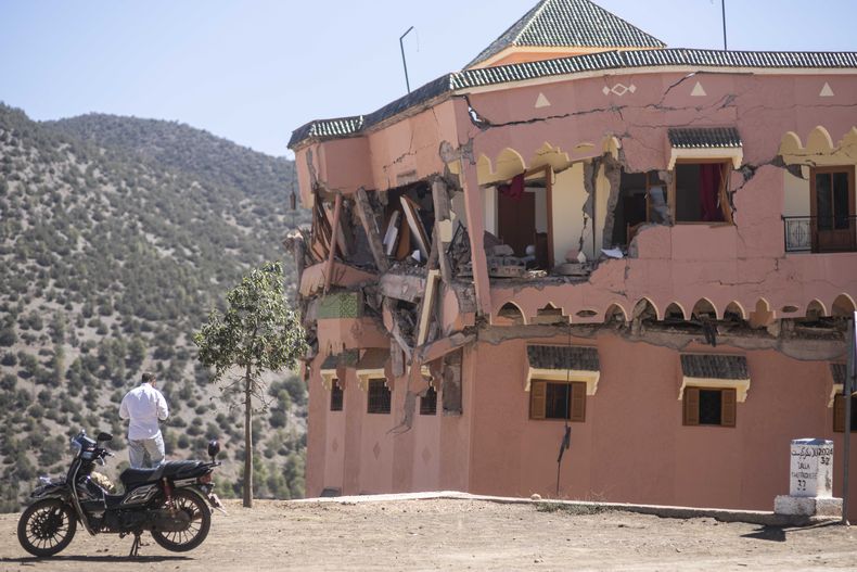 Un hombre de pie junto a un hotel dañado por un sismo en el poblado de Moulay Brahim, cerca del epicentro del sismo, a las afueras de Marrakech, Marruecos, el sábado 9 de septiembre de 2023. (AP Foto/Mosaab Elshamy)