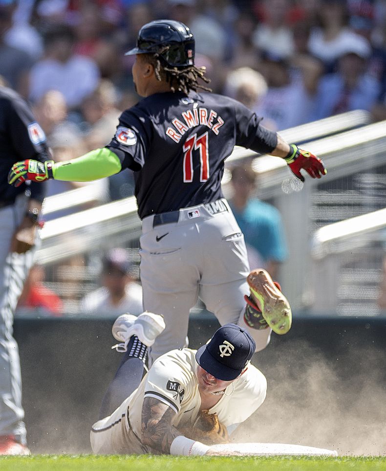 El tercera base de los Mellizos de Minnesota, José Miranda (64), se lanza a primera para sacar a José Ramírez (11), de los Guardianes de Cleveland, para cerrar la parte alta de la sexta entrada de un juego de béisbol en Minneapolis, Minnesota, el domingo 11 de agosto de 2024. (Elizabeth Flores/Star Tribune vía AP)