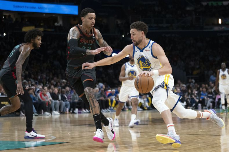 El base de los Warriors de Golden State Klay Thompson avanza hacia la canasta mientras lo defiende el alero de los Wizards de Washington Kyle Kuzma en el encuentro del martes 27 de febrero del 2024. (AP Foto/Manuel Balce Ceneta)