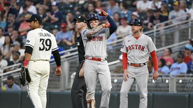 Alex Verdugo, centro, de los Medias Rojas de Boston, celebra después de batear un sencillo productor a un costado del primera base de los Mellizos de Minnesota, Donovan Solano (39) y el coach de primera base de Boston, Kyle Hudson, durante la octava entrada del juego de béisbol, el lunes 19 de junio de 2023, en Minneapolis. (AP Foto/Craig Lassig)