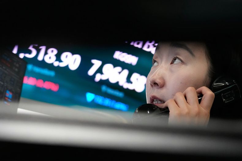 Una operadora de divisas habla por teléfono junto a una pantalla que muestra el Korea Composite Stock Price Index (KOSPI) y la tasa de cambio entre el dólar estadounidense y el won surcoreano, en la sala de operaciones del Hana Bank en Seul, Corea del Sur, el miércoles 10 de junio de 2026. (AP Foto/Ahn Young-joon)