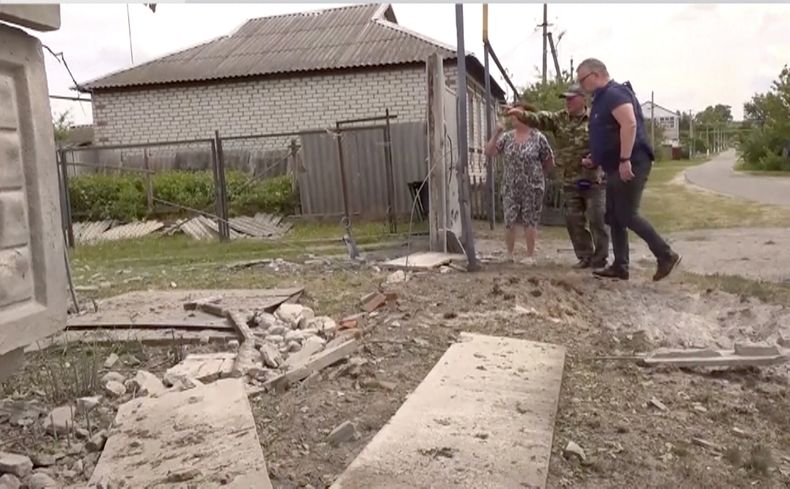Esta imagen tomada de un video muestra a personas señalando a un edificio dañado en la región de Belgorod, el lunes 22 de mayo de 2023, en Rusia. (AP Foto)