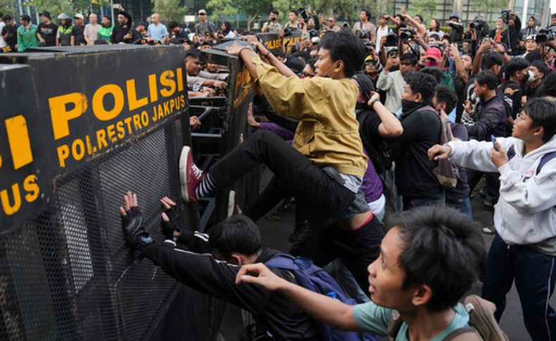 Estudiantes intentan derribar una barricada policial durante una protesta contra el aumento del precio del combustible, el gasto público ineficiente y la injerencia militar en asuntos civiles en Yakarta, Indonesia, el viernes 12 de junio de 2026. (Foto AP/Dita Alangkara)