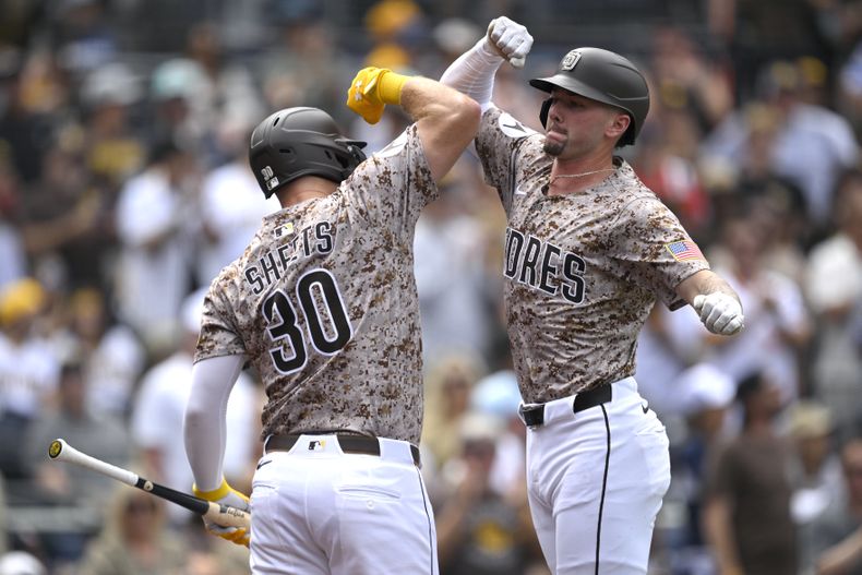 Jackson Merrill, derecha, de los Padres de San Diego, celebra con Gavin Sheets (30) después de batear un cuadrangular de tres carreras durante la segunda entrada del juego de béisbol de Grandes Ligas contra los Rockies d Colorado, el domingo 14 de septiembre de 2025, en San Diego. (AP Foto/Orlando Ramirez)