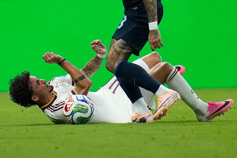 El español Yeremy Pino en el piso ante el uruguayo Brian Rodríguez en el partido por el Group H del Mundial, el viernes 26 de junio de 2026, en Guadalajara. (AP Foto/Ricardo Mazalán)