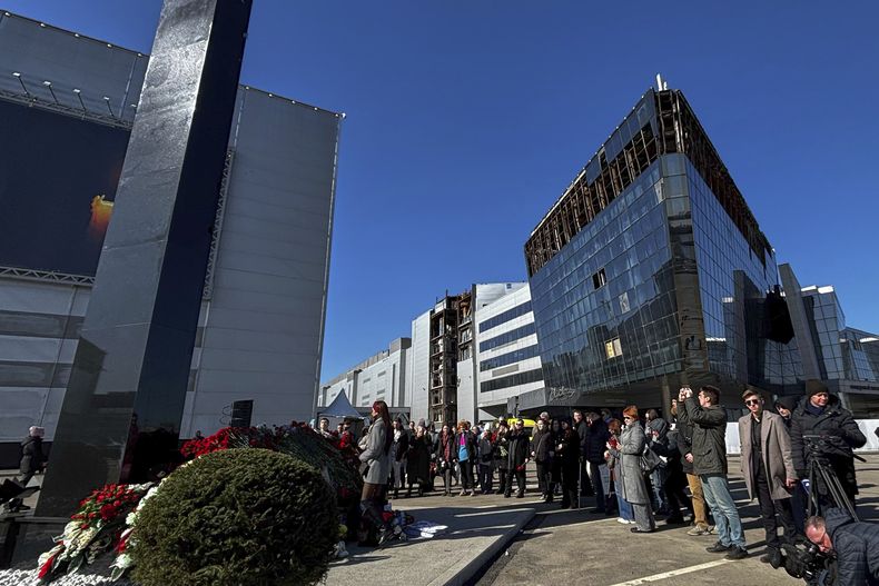 Una multitud se reúne para depositar flores en el recién develado monumento en honor a las víctimas de la masacre en Crocus City Hall, en las afueras de Moscú, Rusia, el sábado 22 de marzo de 2025, en el primer aniversario del ataque en la sala de conciertos, en el que murieron 145 personas. (AP Foto/Pavel Bednyakov)