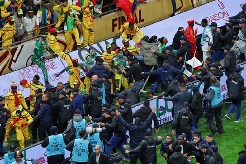 ARCHIVO - Hinchas senegaleses chocan con empleados de seguridad tras la marcación de un penal a favor de Marruecos en la final de la Copa Africana, el 18 de enero de 2026 (AP Foto/Youssef Loulidi, archivo)