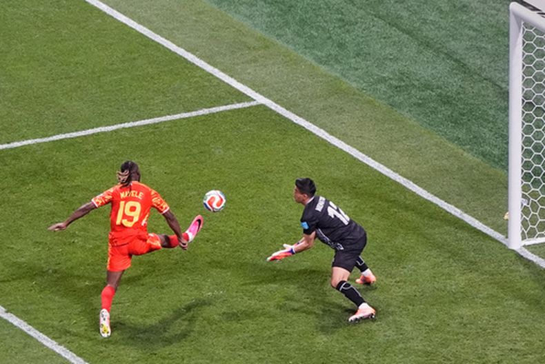 Fiston Mayele (19) del Congo anota el segundo gol de su equipo al vencer al arquero de Uzbekistán Abduvohid Nematov (12) durante su partido por el Grupo K del Mundial, el 27 de junio de 2026, en Atlanta. (AP Foto/Mike Stewart)