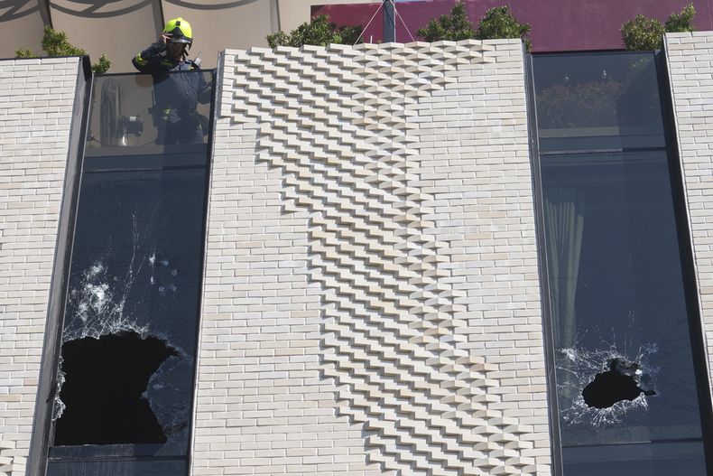Un bombero comprueba las ventanas rotas de un hotel en Bangkok, Tailandia, el lunes 30 de diciembre de 2024, después de un incendio. (AP Foto/Sakchai Lalit)