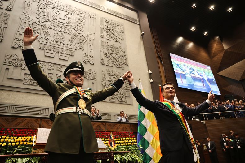 El presidente Rodrigo Paz, a la derecha, y el vicepresidente Edman Lara se toman de las manos después de la ceremonia de juramentación en La Paz, Bolivia, el sábado 8 de noviembre de 2025. (Luis Gandarillas, Pool Foto vía AP)