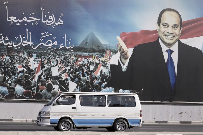 Un minibús pasa bajo un cartel en apoyo del presidente de Egipto, Abdul Fatá el Sisi, para las elecciones presidenciales, en El Cairo, Egipto, el domingo 10 de diciembre de 2023. Los egipcios empezaron a votar el domingo en unas elecciones presidenciales en las que El Sisi, que no enfrentaba a ningún rival serio, ganaría con certeza otro mandato, lo que le mantendría en el poder hasta 2030. (AP Foto/Amr Nabil)