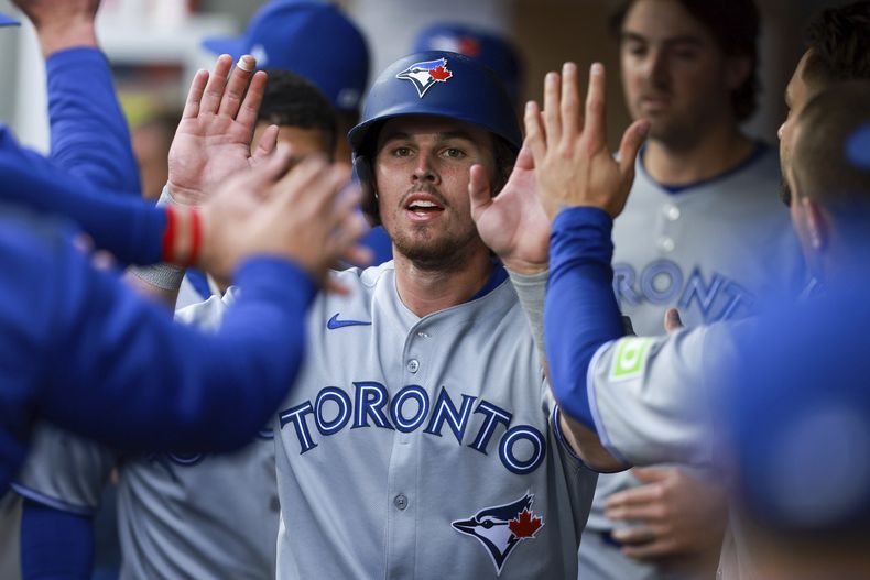 Addison Barger (centro) es felicitado en la cueva tras anotar ante los Marineros de Seattle, el viernes 9 de mayo de 2025. (AP Foto/Rio Giancarlo)