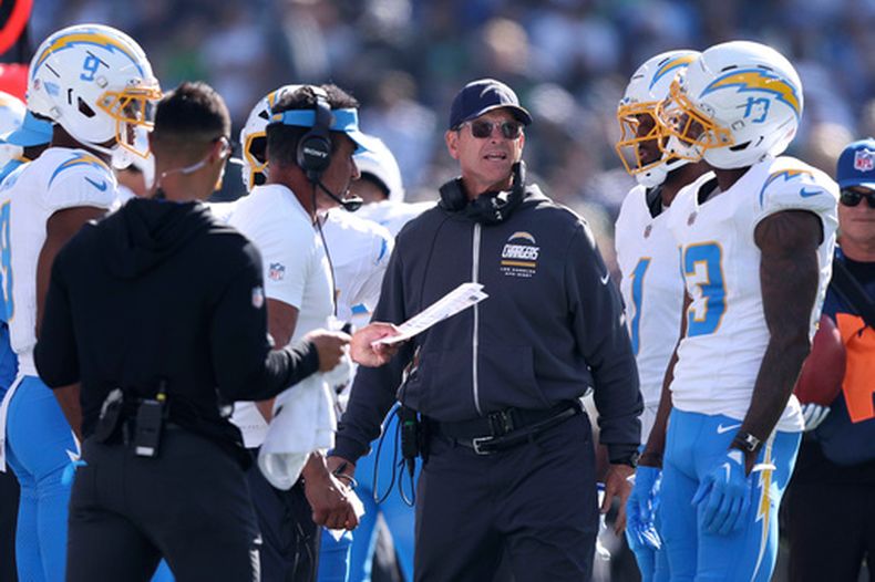 Jim Harbaugh, centro, entrenador en jefe de los Chargers de Los Ángeles, reacciona en la banda durante la primera mitad del partido de la NFL en contra de los Seahawks de Seattle, el domingo 4 de octubre de 2026, en Seattle. (AP Foto/Kevin Ng)