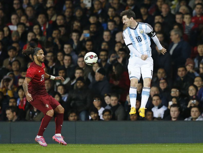 El jugador de Argentina y del Barcelona, Lionel Messi, derecha, cabecea un bal&oacute;n en un partido contra Portugal el martes, 18 de noviembre de 2014, en Manchester, Inglaterra. (AP Photo/Jon Super)