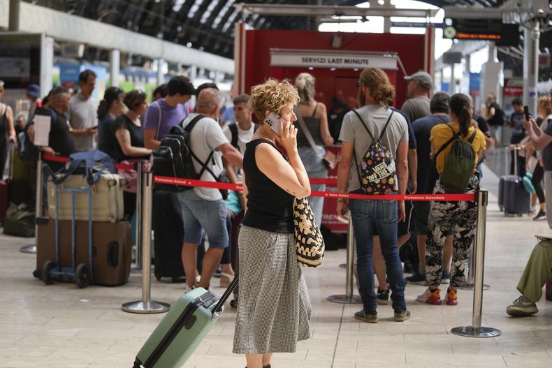 Pasajeros hacen fila en la taquilla de Trenitalia en la estación central de Milán durante una huelga ferroviaria nacional, jueves 13 de julio de 2023. (AP Foto/Luca Bruno)