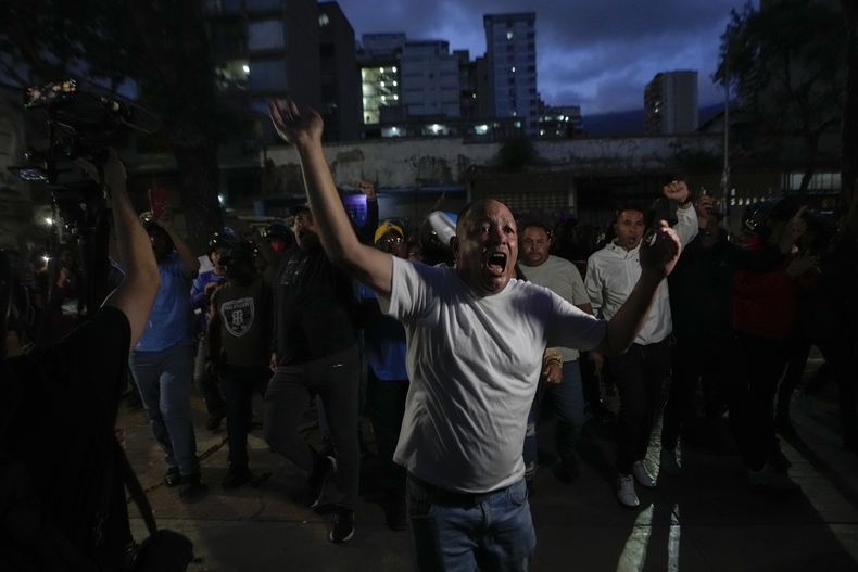Simpatizantes del presidente, Nicolás Maduro, gritan a seguidores de la oposición fuera de un centro de votación en Caracas, Venezuela, el domingo 28 de julio de 2024. (AP Foto/Matías Delacroix)