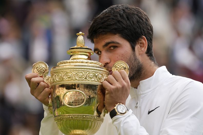 Carlos Alcaraz besa el trofeo de campeón de Wimbledon tras derrotar a Novak Djokovic en la final masculina, el domingo 16 de julio de 2023, en Londres. (AP Foto/Kirsty Wigglesworth)
