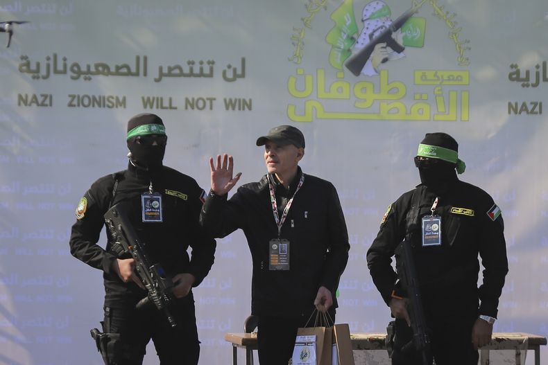ARCHIVO - El rehén israelí-estadounidense Keith Siegel, de 65 años, en el centro a la izquierda, saluda mientras es escoltado por combatientes de Hamás para ser entregado a la Cruz Roja en Ciudad de Gaza el sábado 1 de febrero de 2025. (AP Foto/Mohammed Hajjar, Archivo)
