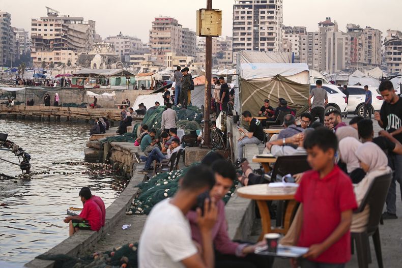 Palestinos en la costa, cerca de un campamento de carpas en el puerto de Ciudad de Gaza, el viernes 13 de junio de 2025. (AP Foto/Jehad Alshrafi)
