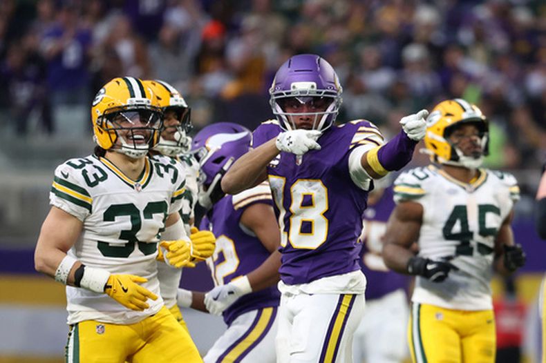 Justin Jefferson (18), receptor abierto de los Vikings de Minnesota, celebra frente al safety estadounidense Evan Williams (33), de los Packers de Green Bay, tras atrapar un pase durante la primera mitad de un juego de fútbol americano de la NFL, hoy domingo 4 de enero de 2026, en Minneapolis. (AP Photo/Ellen Schmidt)