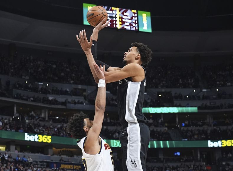 Victor Wembanyama, derecha, de los Spurs de San Antonio, se alza sobre Jamal Murray, de los Nuggets de Denver, para tomar un tiro durante la segunda mitad del juego de baloncesto de la NBA, el viernes 3 de enero de 2025, en Denver. (AP Foto/David Zalubowski)