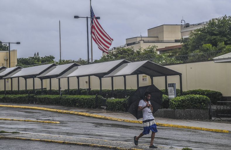 Un hombre camina frente a la embajada de EEUU en Kingston, Jamaica, mientras caen lluvias provocadas por la tormenta tropical Rafael el martes 5 de noviembre de 2024. Rafael se fortaleció el miércoles 6 de noviembre y se convirtió en un ciclón categoría 3 el miércoles 6 de noviembre, en las inmediaciones de las costas sur occidental de Cuba, (AP Foto/Collin Reid)