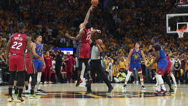 Bam Adebayo (13), del Heat de Miami, y Nikola Jokic, de los Nuggets de Denver, detrás, brincan en el arranque del Juego 1 de las Finales de la NBA, el jueves 1 de junio de 2023, en Denver. (AP Foto/Jack Dempsey)