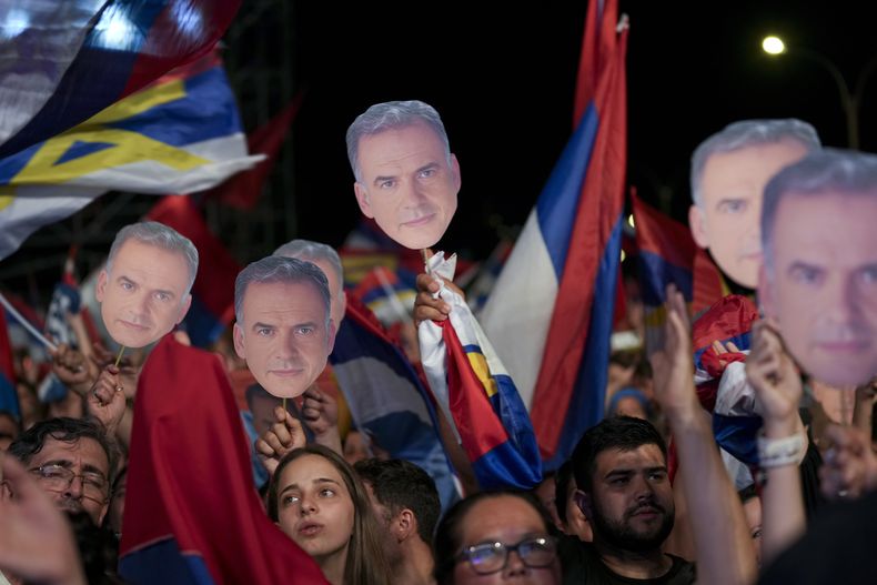 ARCHIVO - Partidarios sostienen recortes del rostro de Yamandú Orsi, candidato del Frente Amplio, después del cierre de las urnas en la segunda vuelta de las elecciones presidenciales en Montevideo, Uruguay, el domingo 24 de noviembre de 2024. (AP Foto/Natacha Pisarenko, Archivo)