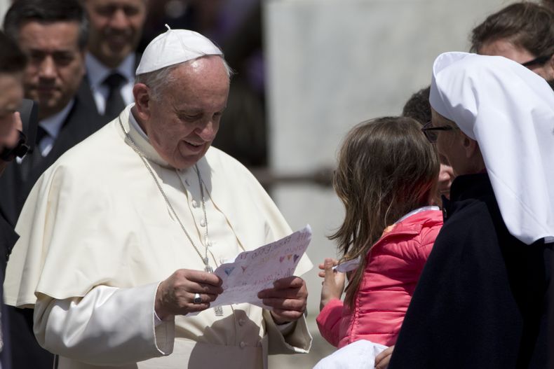 El papa Francisco lee un mensaje que le entreg&oacute; un ni&ntilde;o al final de su audiencia general semanal en el Vaticano, el mi&eacute;rcoles 30 de abril de 2014. (Foto AP/Andrew Medichini)