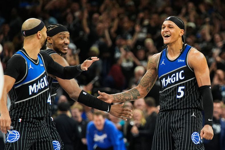 El alero del Magic de Orlando Paolo Banchero celebra con Jalen Suggs y Wendell Carter Jr. su triple ante los Pistons de Detroit el sábado 25 de abril del 2026. (AP Foto/John Raoux)