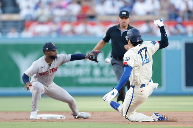 Shohei Ohtani, de los Dodgers de Los Ángeles, se desliza en la intermedia frnete al venezolano Andruw Monasterio, de los Medias Rojas de Boston, el sábado 1 de agosto de 2026 (AP Foto/Caroline Brehman)