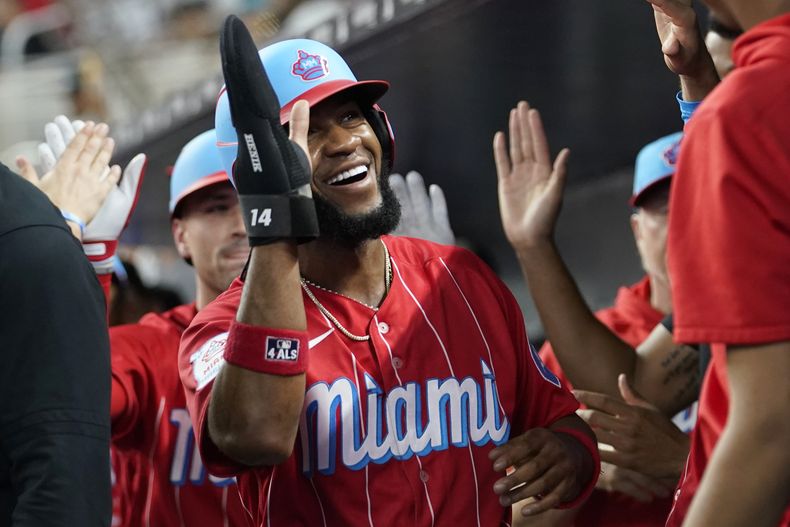 El dominicano Bryan de la Cruz recibe felicitaciones en la cueva luego de anotar en el duelo del sábado 23 de septiembre de 2023, ante los Cerveceros de Milwaukee (AP Foto/Lynne Sladky)