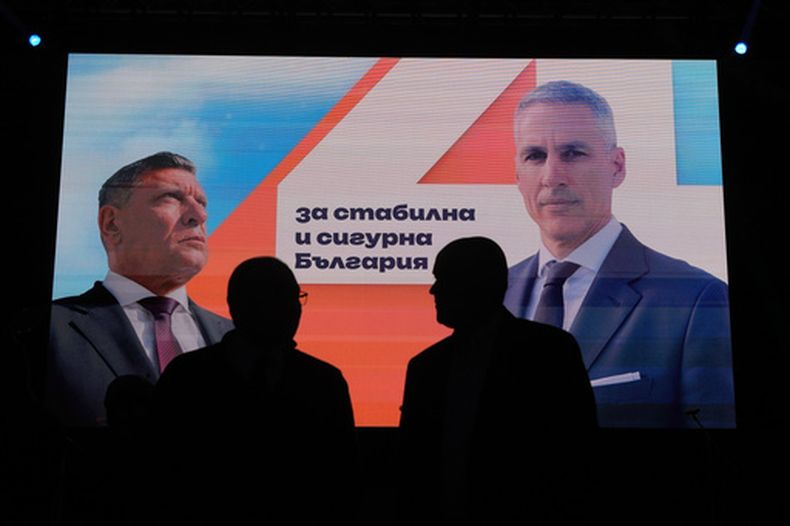 Carteles con la imagen del candidato presidencial independiente Andrey Gyurov y su candidato a vicepresidente, Georgi Kandev, se ven en la pantalla durante su mitin de cierre de campaña en Plovdiv, Bulgaria, el 21 de octubre de 2026. (AP Foto/Valentina Petrova)