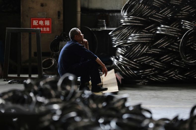 ARCHIVO - Un trabajador descansa en una fábrica de aros de acero para ruedas de bicicleta a exportar a Estados Unidos en Hangzhou, en el este de la provincia china de Zhejiang, el viernes 11 de abril de 2025. (Chinatopix Via AP, Archivo)