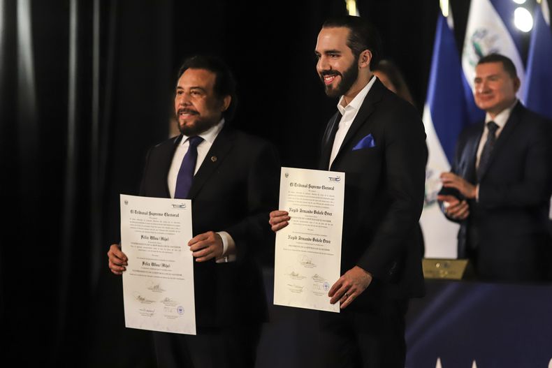 El presidente de El Salvador, Nayib Bukele, a la derecha, y el vicepresidente, Félix Ulloa, con sus credenciales del Tribunal Supremo Electoral que certifican su reelección, en el Teatro Nacional en San Salvador, El Salvador, el jueves 29 de febrero de 2024. (AP Foto/Salvador Meléndez)