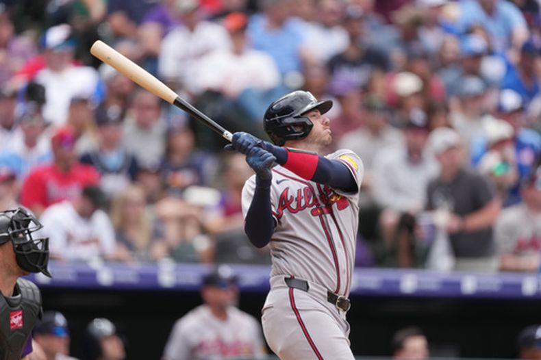 Jonah Heim, de los Bravos de Atlanta, sigue el vuelo de su elevado de sacrificio para impulsar una carrera ante el relevista de los Rockies de Colorado, Antonio Senzatela, en la quinta entrada de un partido de béisbol, el domingo 3 de mayo de 2026, en Denver. (AP Foto/David Zalubowski)