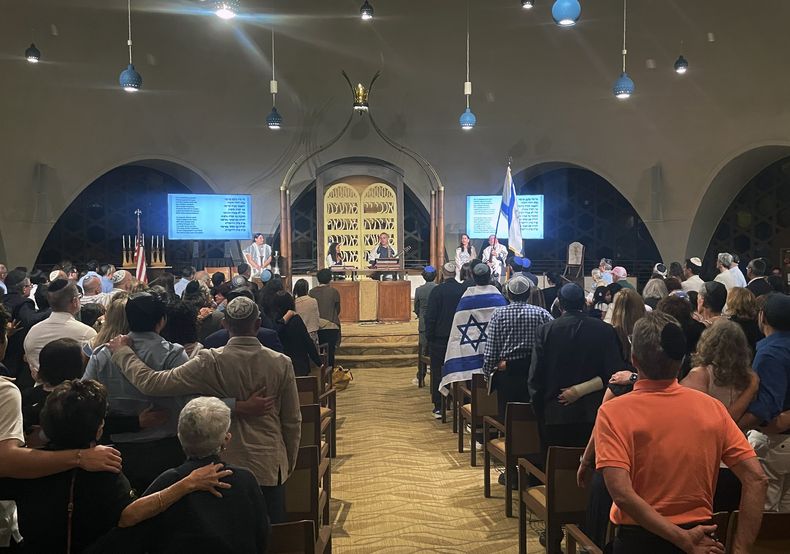 Cerca de 300 personas cantan al final de los servicios del sabat en un templo de Miami Beach, Florida, el viernes 13 de octubre de 2023. (AP Foto/Giovanna DellOrto)